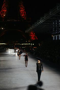 models walk down the runway at night in front of the eiffel tower, paris