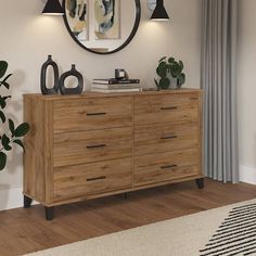 a large wooden dresser sitting under a round mirror