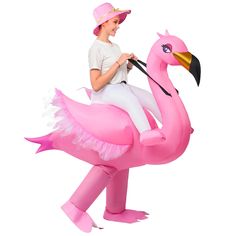 a woman riding on the back of a pink flamingo inflatable