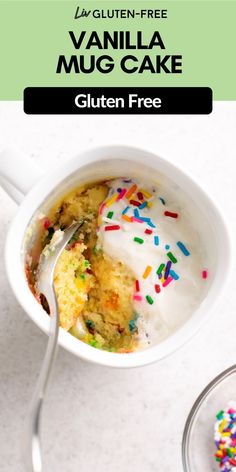 a cup filled with cake and sprinkles on top of a table next to a spoon