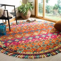 a brightly colored rug with tassels on the floor in front of a window