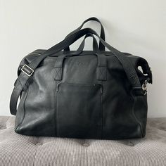 This Is A Stylish, Large Pebbled Leather Weekender From Cole Haan. It Has Been Lightly Used And Well Cared For. It Is Very Spacious With Two Zippered Pockets Inside And A Sturdy Zippered Enclosure Outside. The Base Is 20” Wide And 7” Deep. The Full Height From Top To Bottom Is 16 1/2”. Designer Black Duffle Bag For Everyday Use, Black Textured Leather Luxury Duffle Bag, Classic Black Textured Leather Travel Bag, Designer Black Weekender Bag, Designer Black Weekender Bag For Daily Use, Designer Black Weekender Bag With Leather Handles, Classic Black Textured Leather Duffle Bag, Casual Black Travel Bag With Leather Trim, Designer Black Satchel With Leather Lining