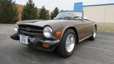 a brown sports car parked in a parking lot