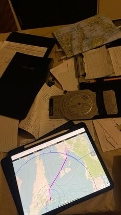 a laptop computer sitting on top of a desk covered in papers