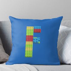 the letter f made out of lego blocks on a blue background throw pillow by pixelpix