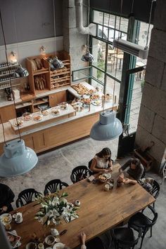 a woman sitting at a table in a bakery