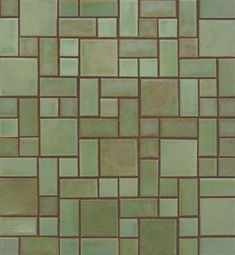 a close up view of a tile floor with green and brown squares on the tiles