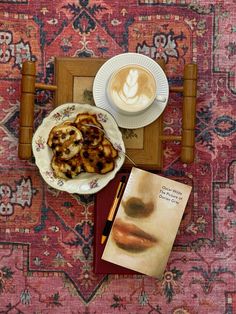 a table topped with a plate of food next to a cup of cappuccino