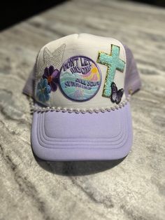 a purple and white hat with a cross on it