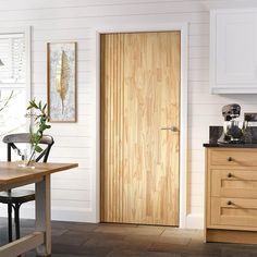 a wooden door in a kitchen next to a table