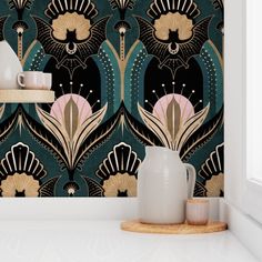 a vase sitting on top of a counter next to a wallpaper covered in black and gold designs