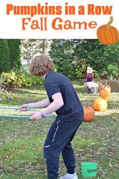 a young boy is playing with pumpkins in a row at the fall game for kids