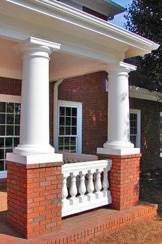 a brick building with white pillars and windows