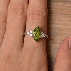 It is a natural peridot ring. The main stone is 6mm*12mm marquise cut, weight about 1.55 carats. The basic metal is sterling silver and plated with rhodium. To change the metal to a solid gold (white/rose) or platinum is also available, please ask for a quotation if you want. You can also go to my shop Home for more elegant rings: https://www.etsy.com/shop/godjewelry?ref=hdr_shop_menu More peridot rings: https://www.etsy.com/shop/godjewelry?section_id=20709252 Customization is always welcome and Green Marquise Diamond Promise Ring, Green Marquise Cut Birthstone Jewelry, Peridot Rings, Elegant Rings, Engagement Rings Marquise, August Birthstone, Peridot Ring, Elegant Ring, August Birth Stone