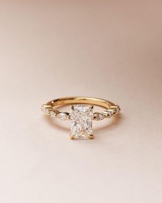 a gold ring with a princess cut diamond