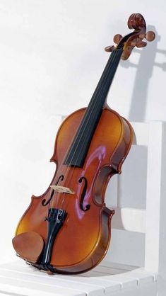 a violin sitting on top of a white shelf