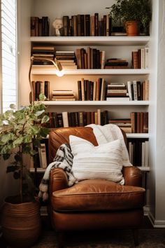 a brown leather chair sitting in front of a book shelf filled with books