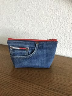 a small denim pouch sitting on top of a wooden table next to a white wall