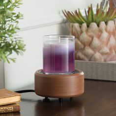 a purple candle sitting on top of a wooden table