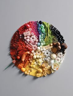 there are many different colors of beads on the table and one has a green toothpick in it