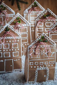 four gingerbread houses with candy canes tied to them