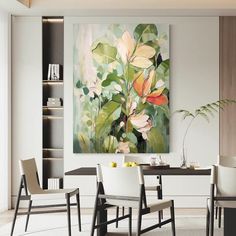 a painting hanging on the wall above a dining room table with chairs and a vase filled with flowers