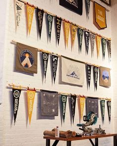 there are many pennants hanging on the wall next to a table with a sewing machine