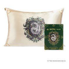 the harry potter pillow and book are on display in front of a white background with gold trim