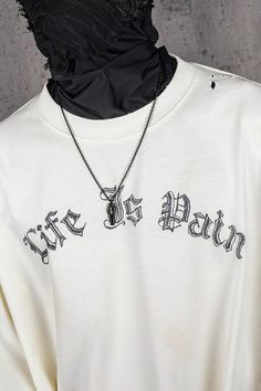 a white shirt with black writing on it and a chain attached to the neckline