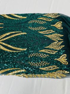 green and gold sequinned fabric on white background