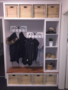 a coat rack with baskets and coats hanging on it