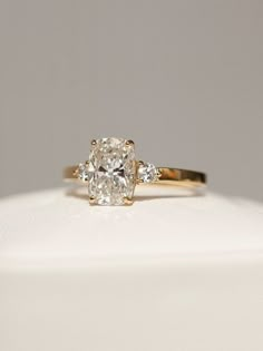 a yellow gold engagement ring with an oval cut diamond