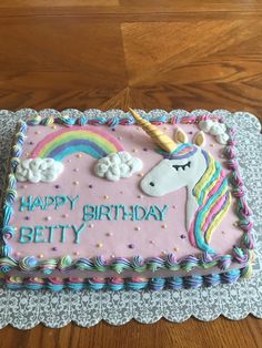 a birthday cake decorated with an unicorn and rainbow