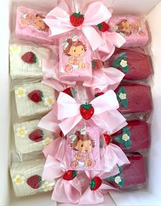 strawberry shortcakes wrapped in cellophane and tied with pink ribbon are arranged in a box