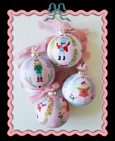 three christmas ornaments with pink bows on them and a ribbon tied around one ornament