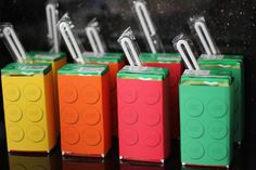 four lego style toothbrushes are lined up in different colors and shapes, each with an individual toothbrush holder