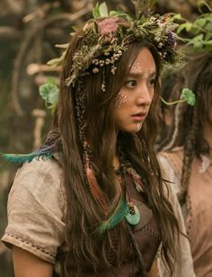 two women with flowers in their hair and one wearing a flower crown on her head