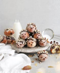 a pile of doughnuts sitting on top of a plate next to a glass of milk