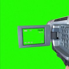 a close up of a person holding a machine with a green screen in the background