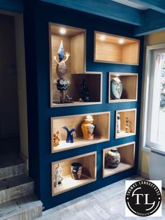 shelves with vases and other decorative items on them in a room that is painted blue