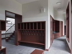 an empty room with wooden lockers and benches