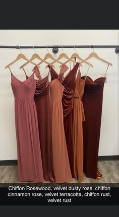 four dresses hanging on a rack in front of a wall with the caption,