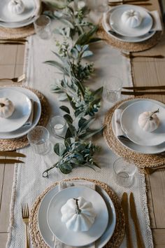 the table is set with white plates and silverware