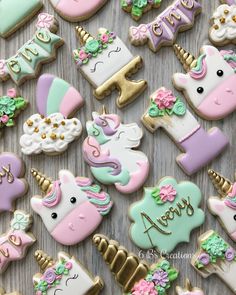 cookies decorated with pastel colors and unicorns are displayed on a wooden table top