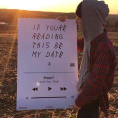 a man holding up a sign that says if your reading this be my date