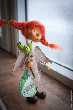 a doll with red hair holding a flower