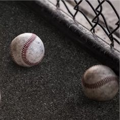 two baseballs and a bat on the ground