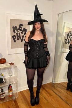 a woman in a black dress and witch hat