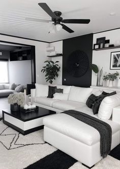 a living room with white furniture and black accents