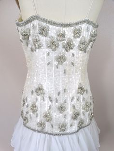 "This is a gorgeous little vintage couture dress! It's completely hand sewn, embellished with white sequins, glass beading and accented with iridescent rhinestone crystals. It's in excellent condition! Bust - 36\" Waist - 29\" Hips - 38\" Length - 33\" Tag Size - 8 All of my items come from a pet-free and smoke-free home. If you would like more info or have any questions, please don't hesitate to ask!" White Strapless Sequin Evening Dress, Fitted Sequin Dress With Rhinestones And Sweetheart Neckline, Couture Embellished Dress With Fitted Bodice, Couture Embellished Evening Dress, White Fitted Embellished Corset Dress, Fitted White Embellished Corset Dress, Sleeveless Sequin Corset Dress With Fitted Bodice, Fitted Sequined Corset Evening Dress, Glamorous Sequined Corset Dress For Weddings